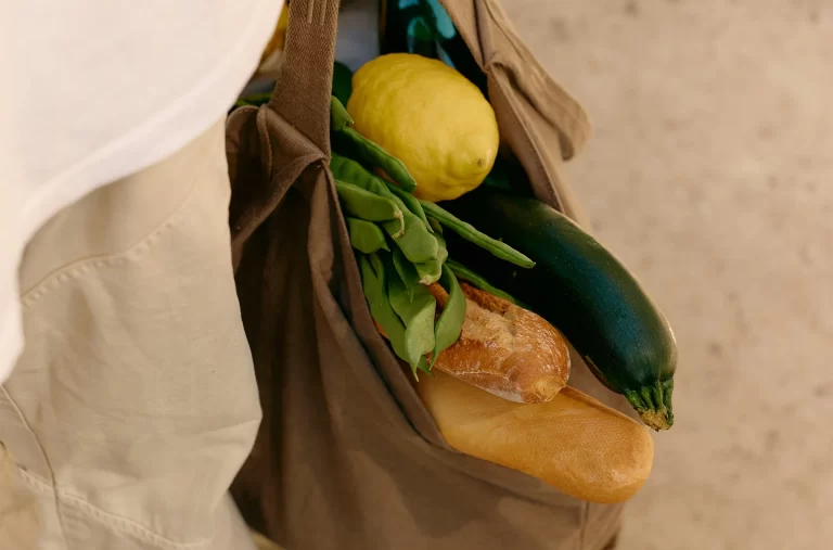 Sacola de compras com pão, abobrinha, limão e verduras