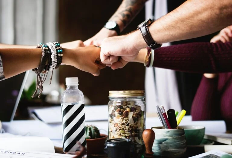 Equipe unindo os punhos sobre uma mesa de trabalho